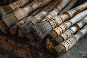 Many handmade artistic paintbrushes laying on wood surface photo