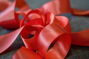 Red ribbon creating abstract shape on grey background photo