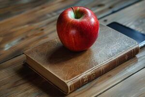 Red apple resting on antique book and smartphone on wooden table photo