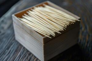 Wooden toothpicks filling a small container on a rustic table photo