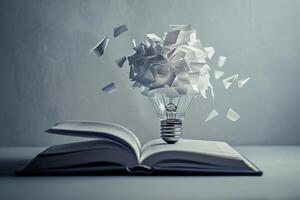 Crumpled paper exploding from light bulb balancing on open book symbolizing ideas photo