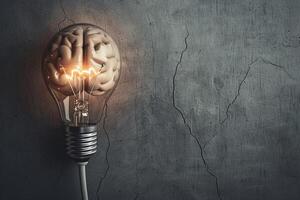 Brain generating ideas inside light bulb in front of concrete wall photo