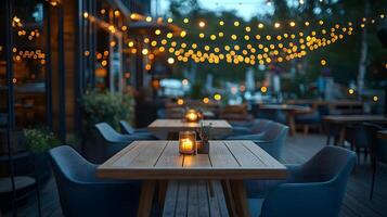 Outdoor restaurant terrace features wooden dining tables and modern grey chairs, illuminated by string lights. Deck flooring and candlelight create warm evening ambiance for cozy patio lights photo