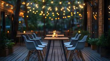 Outdoor restaurant terrace features wooden dining tables and modern grey chairs, illuminated by string lights. Deck flooring and candlelight create warm evening ambiance for cozy patio chairs photo