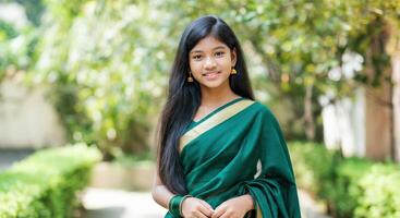 Young asian female in traditional green sari outdoors amidst lush garden setting photo