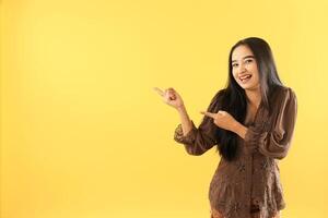 Indonesian Women Wear Traditional Clothes with Presenting Hands Gesture for Presenting a Product photo