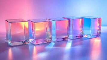 Transparent glass cubes arranged in a row displaying iridescent reflections and holographic effects, illuminated by pink and blue gradient lighting on a white background. crystal photo