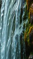 A person is sitting on a bench next to a waterfall photo