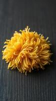 A pile of yellow spaghetti on a wooden table photo