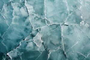 Turquoise ice covering water surface creating abstract shapes photo