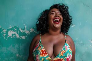 Plus size black woman laughing with turquoise wall background photo