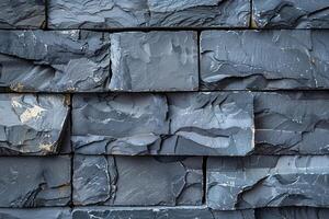 Dark grey stone wall cladding forming textured background photo