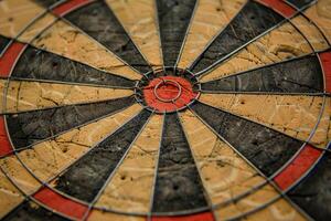 Close up of worn dartboard showing center bullseye and wire separators photo