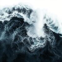 Giant waves crashing in the ocean creating white foam on dark blue water photo