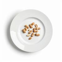 Peanuts with and without shell resting on white plate photo