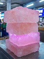 Stack of pink ice blocks on a metal surface photo