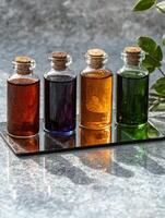Four bottles of essential oils on a reflective surface photo