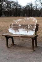 Large block of ice on a park bench photo