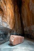 Large rough hewn stone block in a cavernous setting photo