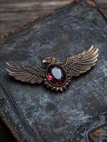 Bronze eagle brooch with dark red gemstone photo