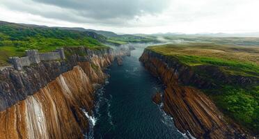 Spectacular aerial view of a medieval castle perched atop dramatic cliffs overlooking a serene ocean inlet photo