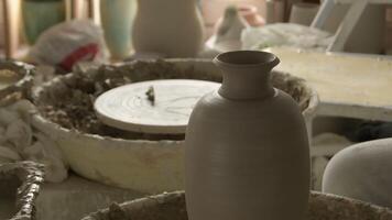 Vase of mud or clay recently made by a potter spinning in the lathe video