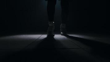 Legs close-up of jumping rope in a dark room with smoke with back light in front, slow motion video