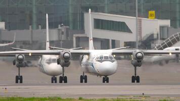 Aircrafts taxiing. Turboprop aircraft with unrecognizable livery one after another on the airfield, front view video