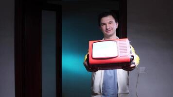 Man showing old portable television with blank screen video