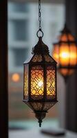 Hanging Islamic lantern with intricate patterns glowing warmly, creating a serene ambiance, with a blurred background for a minimalist aesthetic. Vertical banner for spring holiday photo