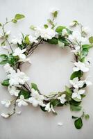 Delicate floral wreath made of intertwined branches, white blossoms, and green leaves, set against a textured light background, evoking simplicity and natural beauty. photo