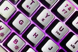 Macro photo of keyboard button with purple bright backlit color