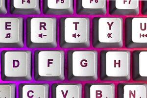 Macro photo of keyboard key with purple backlit light