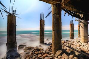 Scenic Coastal View with an Old Bridge Overlooking the Sea. Tranquil Ocean with Shimmering Blue Waves. photo