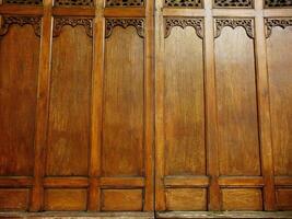 Javanese traditional wooden paneling has a rustic and old fashioned look to it. The wood grain is visible and the paneling is slightly worn, giving the room a cozy feel photo