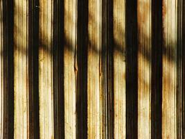 Abstract background texture of a wooden surface with a pattern of stripes. The stripes are faded and the surface appears to be old and worn. Scene is somewhat somber and nostalgic photo