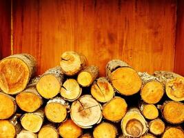 Pile of wood logs stacked on top of each other. The wood logs are of different sizes and shapes. Concept of warmth and coziness, as the wood logs are stacked together. photo