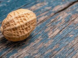 Single peanut in shell on rustic wooden surface photo