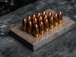 Close up of 9mm bullets arranged on a rustic surface photo