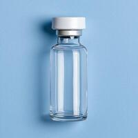 Empty glass vial with white cap on blue background photo