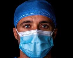 Close up portrait of a doctor wearing a surgical mask and cap. photo