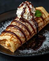 Delicious crepe topped with chocolate sauce and whipped cream. photo