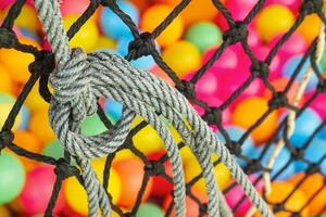 The net rope and colorful ball in children's playroom. Tight knot is used for safety barrier net. Children's playground photo