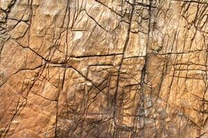 Background and texture of mountain layers and cracks in sedimentary rock on cliff face. Stone texture closeup background. Close-up of interior material for design decoration background photo