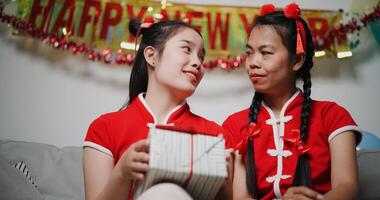 Cheerful young woman holds a gift and talks happily with her mother in a cozy living room photo
