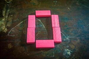Red wooden blocks arranged in the shape of the number zero on a rustic wooden surface. Perfect for educational, numerical, or creative concepts photo