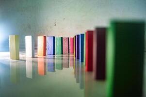 Colorful wooden blocks in a line on a reflective surface, creating a vibrant pattern photo