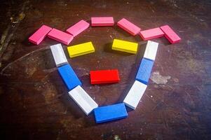 Colorful wooden blocks arranged in a smiley face pattern on a wooden surface, showcasing creativity and playful design photo