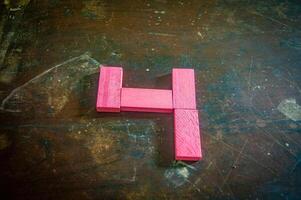 Red wooden blocks arranged in the shape of the number four on a rustic wooden surface. Perfect for educational, numerical, or creative concepts photo