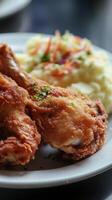 Crispy fried chicken legs with mashed potatoes and coleslaw photo